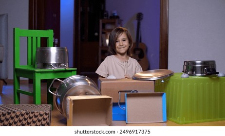 portrait of a little girl playing drums made of pots and boxes - Powered by Shutterstock