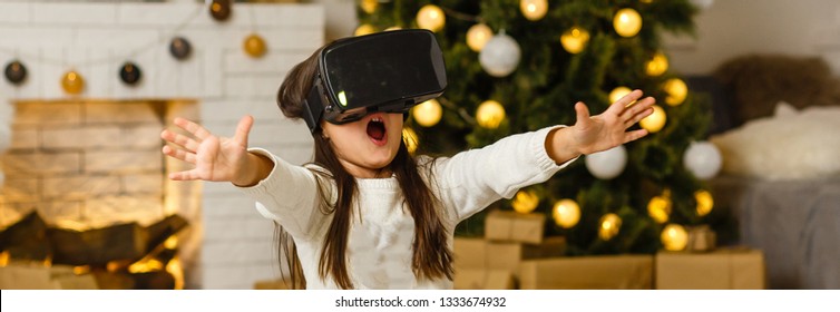 Portrait of little girl playing in virtual reality headset at home - Powered by Shutterstock