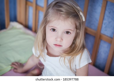 portrait of a little girl sitting in bed