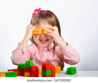 Portrait Of A Little Girl Who Plays The Designer. On A White Background.