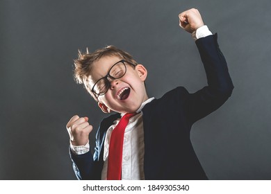 Portrait of little kid businessman celebrating victory. Say yes. Child winner excited and raising up hands in triumph. Achieving success grinning from delight. Caucasian female student boy - Powered by Shutterstock