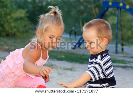 Similar – children playing in the sand, having a conversation over sand toys