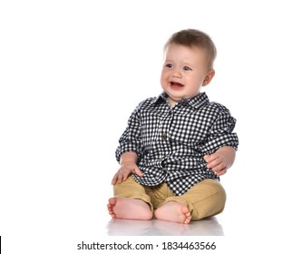 Portrait of a little one year old baby boy on a white background. Boy is sitting in a shirt and pant with tears in his eyes. Boy is capricious because his toy was taken away. 