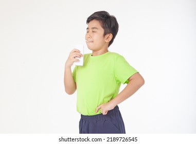 Portrait Of A Little Young Handsome Kid Boy In Green Shirt, Hold Drinking Milk Box Mockup, Isolated On White Background. Concept Of Happy Good Nutrition