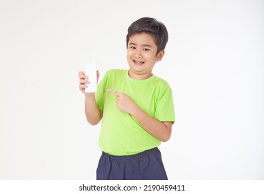 Portrait Of A Little Young Handsome Kid Boy In Green Shirt, Hold Drinking Milk Box Mockup, Isolated On White Background. Concept Of Happy Good Nutrition