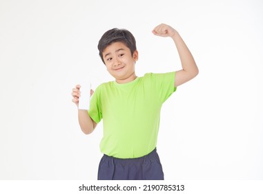 Portrait Of A Little Young Handsome Kid Boy In Green Shirt, Hold Drinking Milk Box Mockup, Isolated On White Background. Concept Of Happy Good Nutrition