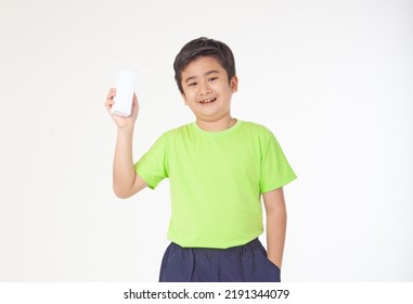 Portrait Of A Little Young Handsome Kid Boy In Green Shirt, Hold Drinking Milk Box Mockup, Isolated On White Background. Concept Of Happy Good Nutrition