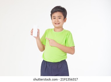 Portrait Of A Little Young Handsome Kid Boy In Green Shirt, Hold Drinking Milk Box Mockup, Isolated On White Background. Concept Of Happy Good Nutrition