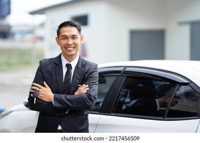 Portrait Of A Loan Car Insurance Agent Smiling Professionally Watching An Asian Car Dealer Stand In Front Of A New Car. Automotive Business Idea