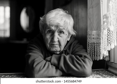 Portrait Of A Lonely Sad Old Woman. Black And White Photo.