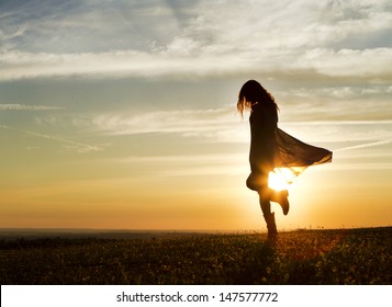 Portrait of a Long haired woman walking with the sun setting behind her
