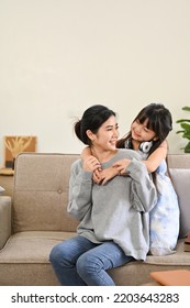 Portrait, Lovely Asian Mom And Little Young Daughter Playing, Relaxing And Spending Time Together In Their Living Room.