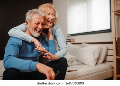 Portrait of lovely couple enjoying in their relationship. Smiling couple is having phone call while they are in bed. - Powered by Shutterstock