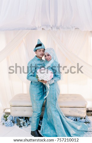 Portrait of lovely couple in reception wedding event with decoration. Asian traditional wedding dress fashion. 