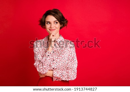 Portrait of lovely curious cheerful brown-haired girl overthinking looking aside copy space isolated over bright red color background