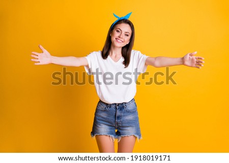 Portrait of lovely glad girl meet you friend want hug open hands wear blue pin-up isolated on yellow color background