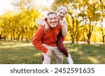 Portrait of lovely happy elderly couple on morning run outside in city park, retirees wife and husband rejoice in active lifestyle, smiling woman tenderly embracing her spouse after routine jogging