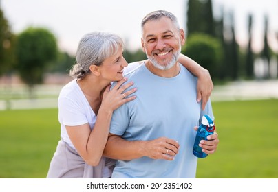 Portrait of lovely happy elderly couple on morning run outside in city park, retirees wife and husband rejoice in active lifestyle, smiling woman tenderly embracing her spouse after routine jogging - Powered by Shutterstock