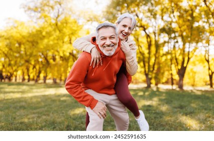 Portrait of lovely happy elderly couple on morning run outside in city park, retirees wife and husband rejoice in active lifestyle, smiling woman tenderly embracing her spouse after routine jogging - Powered by Shutterstock