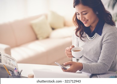 Portrait Of Lovely Indonesian Woman Drinking Coffee And Text Messaging