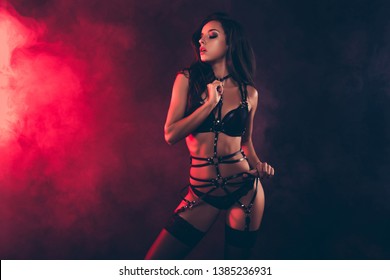 Portrait of lovely magnificent stunning gorgeous charming adorable attractive sporty wavy-haired lady wearing tightening swordbelt teasing isolated over black red light background