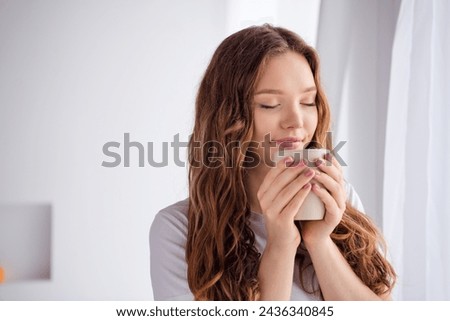 Portrait of lovely peaceful girl closed eyes smell fresh aroma coffee mug comfy morning atmosphere bedroom indoors