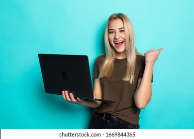 Portrait of a lovely pretty girl holding laptop computer while looking at camera isolated over blue background - Shutterstock ID 1669844365