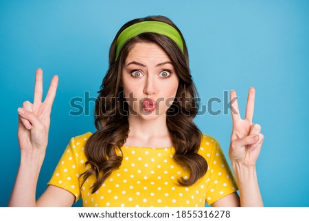 Portrait of lovely pretty girl make v-sign send air kiss isolated over blue color background