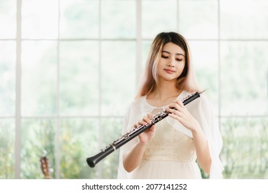 Portrait Of A Lovely Woman Playing The Transverse Flute. Beautiful Asian Female Artists, Classical Musicians