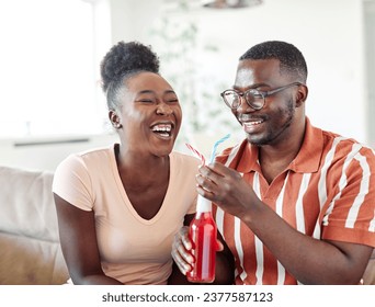 Portrait of a lovely young couple having fun and laughing sharing a drink together at home - Powered by Shutterstock