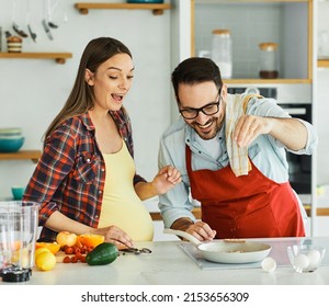 Portrait of a lovely young couple, a pregnant woman,  preparing a healthy meal in the kitchen - Powered by Shutterstock