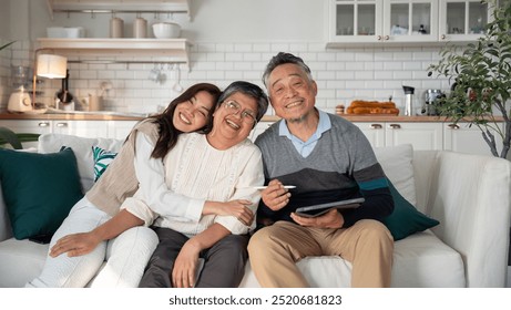 Portrait of Loving Asian Family , Mature Asian Parents with Young Daughter on sofa in living room at home
