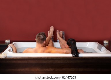 Portrait of loving couple embracing, lying in jacuzzi, relaxing.