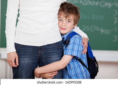 Portrait of loving schoolchild hugs his mother after school