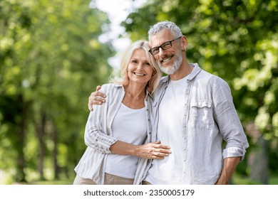 Portrait Of Loving Senior Couple Embracing Outdoors And Smiling At Camera, Romantic Mature Spouses Hugging While Posing Together Outside, Older Man And Woman Bonding While Walking In Summer Park - Powered by Shutterstock