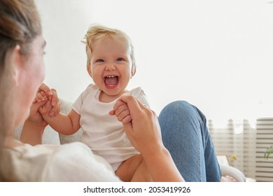 Portrait of a loving young mother holding her toddler child. Woman with her blonde child having fun at home. Close up, copy space for text, background. - Powered by Shutterstock