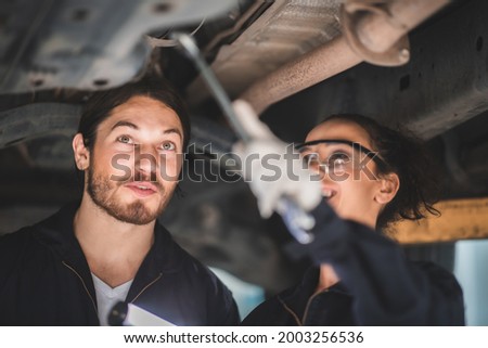 a portrait of machanic while maintennance a car, women and men are co-workers, discussing on work job, work concept in garage. closeup face