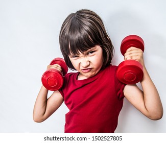 Portrait Of A Mad Frowning Child Expressing Rage And Violence With Dumbbells For Bully Attitude, Feminism, Muscle Power Or Education With Humour, White Background