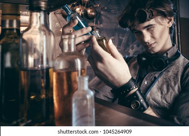 Portrait Of A Mad Scientist Chemist In His Laboratory In The Steampunk Style Of The Victorian Period.