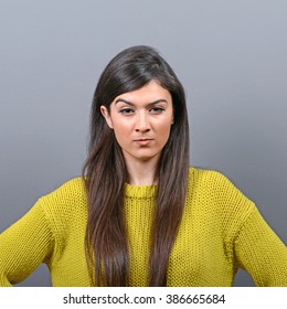 Portrait Of Mad Woman Against Gray Background