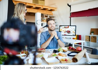 Portrait Of Make-up Artist Applying Finishing Touches To Handsome TV Show Host In Cooking Studio , Copy Space