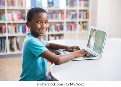 Portrait Of Male African American Student Having A Video Call With Female Teacher On Laptop At Library. Distance Learning Online Education Concept