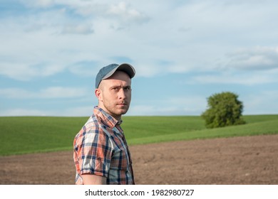 Portrait of a male agronomist who inspects wheat crops in an agricultural field. Farmer in a wheat field. Grain crop yield assessment - Powered by Shutterstock