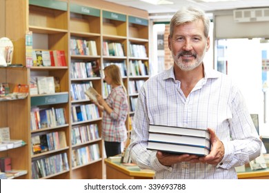 Portrait Of Male Bookstore Owner With Customer In Background