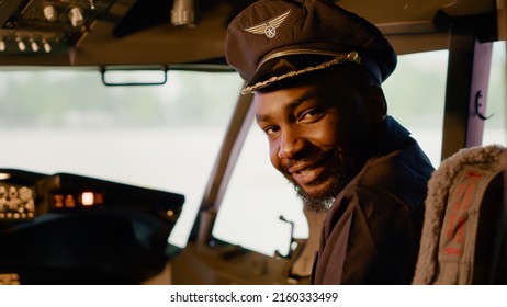 Portrait of male captain sitting in airplane cockpit to start engine, flying plane with dashboard power and control panel command. Windscreen and radar to takeoff, navigation compass.