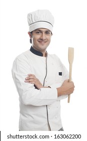Portrait of a male chef holding a spatula and smiling