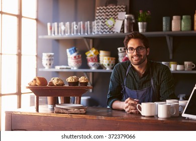 Portrait Of Male Coffee Shop Owner Standing Behind Counter