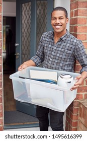 Portrait Of Male College Student Carrying Box Moving Into Accommodation