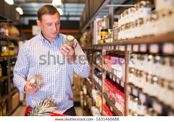 Portrait of\
male customer buying spices in\
supermarket