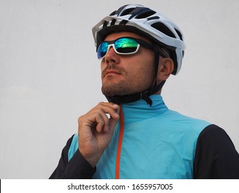 Portrait Of A Male Cyclist Zipping Up A Windbreaker Before Riding A Bike.